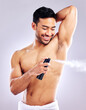 © peopleimages.com - Man, grooming armpit and smile with deodorant in studio background for hygiene, cleanliness and wellness. Male person, happy and confident with body spray for odor, fragrance and fresh scent