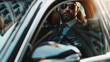 A sophisticated man in sunglasses embodies style as he drives in his sleek, luxurious car.
