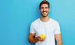 A man is smiling and holding a yellow lemon