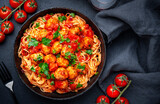 Fototapeta Na sufit - Italian spaghetti pasta in marinara sauce with meatballs, black table background, top view
