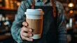 © Nijat - Barista serving coffee in takeaway cup in coffee shop