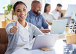 © peopleimages.com - Woman, business and thumbs up in office with laptop, coworking and workplace or company collaboration mission. Employee, achievement and job well done, corporate and online emoji or ok gesture