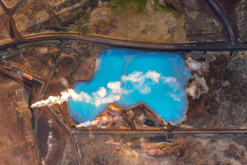 Top drone shot through the clouds of blue lake in the marshes. Myvatn, Iceland, Northeast region.