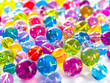 A pile of colorful glass beads on a white background.