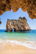 Small, heavenly beach vertically photographed from inside a cave near Portimão, Algarve, Portugal