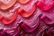 Close-up of glossy red and pink lipgloss swatches with vibrant colors and shiny texture, highlighting the beauty and elegance of professional makeup products.