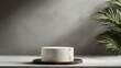 © V.Semeniuk - White marble round stand on wooden counter beside plant in a room with backdrop clear blank wall