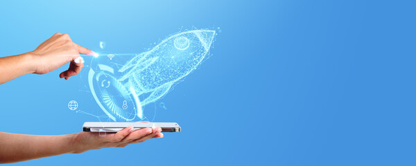 Poster - A hand appears to swipe a holographic image of a rocket from a smartphone, symbolizing a startup launch concept on a blue background