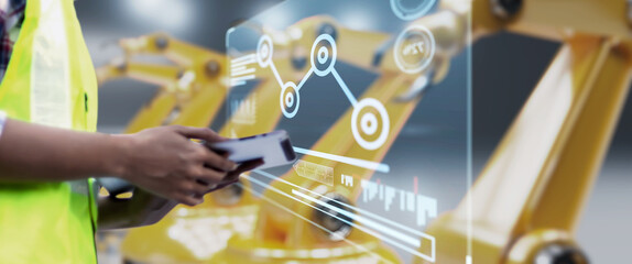 Leinwandbilder - Engineer hand monitoring robotic AI arms in manufacturing factory plant, manager managing controlling using tablet holographic ui display analysis technology, engineer, dark banner background.