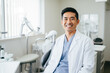 © Dani - Smiling Asian dentist in his clinic consultation