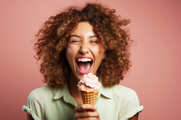 a woman with curly hair holds a pink ice cream cone and smiles against a salmon-colored background. 