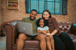© chokniti - Happy African American Family at Home: Mother and Father Hug Their Young Daughter and Son, Sharing Love and Fun Together, Portraying Cheerful Moments of a Black American Household
