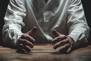 Poster - A man sitting at a table with his hands placed on the table. Suitable for business or education concepts