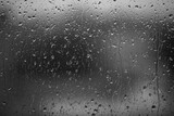 Fototapeta Zachód słońca - Rain drops on window glass closeup macro. Black and white abstract background texture with rain drop