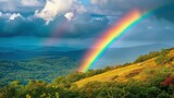 Na tle nieba tęcza łukowata promienieje nad szczytami gór w scenie naturalnej po deszczu. Obraz przedstawia krajobraz z tęczą nad pasmem górskim