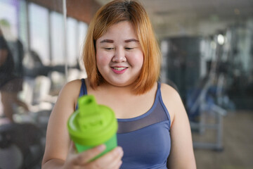 Obese asian woman dieting Weight loss in sportswear drink healthy drink. Sporty asian fat female drinking protein shake After Exercise for Energy wellness health.