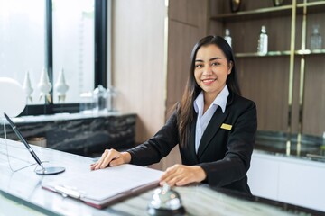 Beautiful asian hotel receptionist in  uniforms at desk in lobby Friendly and welcome staff in hotel reception counter.