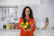 A Beautiful Smiling and happiness fit African American woman showing a bowl fruits in her kitchen. Female athlete slimming, presenting healthy eating and wellbeing food lifestyle for burn calories.