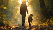 © Vasiliy - A woman and her dog walk through a sunlit forest, forming a beautiful bond between human and pet
