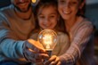 © BoOm - Happy family holding a light bulb in their hands