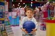 Happy excited boy child with ball during shopping in mall