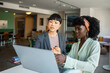 © Marko Geber - Two young businesswomen discussing work over laptop in office