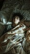 Young man laying in bed under a blanket. Vertical background 