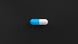 White blue single pill isolated on a black background. Tablet, pill capsule top view, flat lay. 3d render illustration 