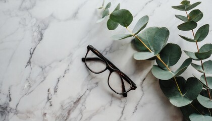 women s glasses and eucalyptus leaves on marble table top view