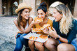 © Xavier Lorenzo - Three multiracial tourist friends having fun eating italian pizza during vacation Travel and holiday lifestyle concept.