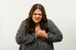 Uncomfortable plus-size woman clutching her chest and having a heart attack in a studio