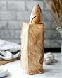 Freshly baked french baguette in paper bag on white table for bakery advertisement