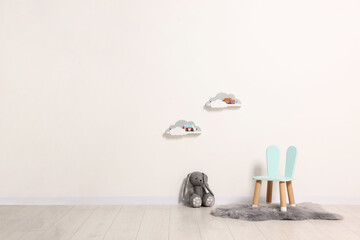 Poster - beautiful children's room with light wall, chair and toys, space for text. interior design