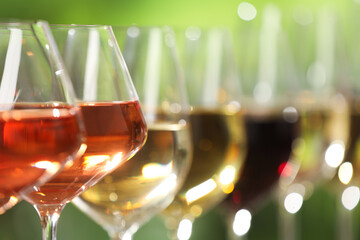 Canvas Print - Different tasty wines in glasses against blurred background, closeup. Space for text