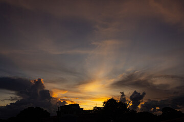 Wall Mural - Sunset sky with clouds and silhouette of the city 