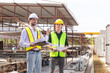 © JU.STOCKER - Engineer and foreman worker team checking project at precast factory site, Engineer and builders in hardhats discussing on construction site