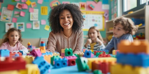 cheerful teacher interacting with children during playtime with colorful blocks