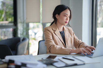 Businesswomen working to analysis strategy and management about new startup project while using technology with digital laptop to typing report about investment and financial of business in workplace