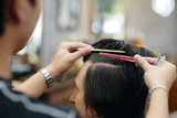 Fototapeta  - Young man cutting hair of client in small barbershop