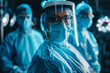 A woman in a blue lab coat with a face mask on stands in front of two other people in blue lab coats