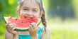 Summer Joy: Young Girl Smiling While Eating Watermelon