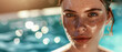 Close-up of a young woman's face glistening by the poolside.