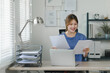 Young businesswoman working from home with laptop and documents. Work life balance concept