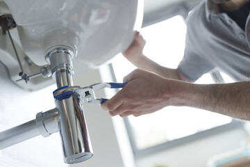 Wall Mural - Professional plumber fixing a leaking sink