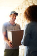 © peopleimages.com - Delivery man, home and package delivery for courier service and e commerce with logistics, transport and supply chain. Customer and worker at front door with box, parcel or order for shopping product