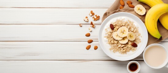 Wall Mural - Healthy and vegetarian breakfast with a white plate containing oatmeal porridge nuts and a banana The image has copy space