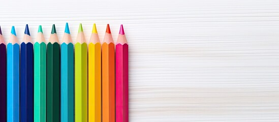 Aufkleber - Colorful drawing pencils arranged on a white wooden surface creating an educational concept The diverse range of hues forms a vibrant rainbow palette providing a copy space image