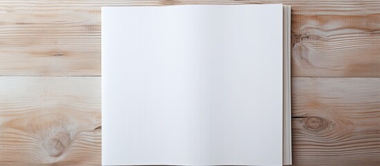 Poster - A blank book cover template with an open page on the front side positioned on a white wood background in a flat lay copy space image