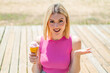Young pretty blonde woman with a cornet ice cream at outdoors with shocked facial expression
