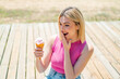 Young pretty blonde woman with a cornet ice cream at outdoors with surprise and shocked facial expression